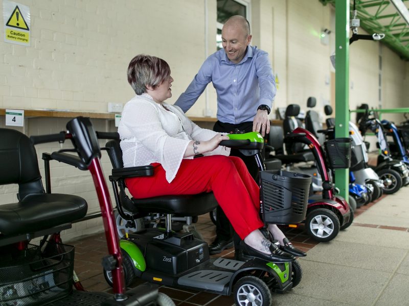 occupational therapist talking to a lady sitting in a scooter